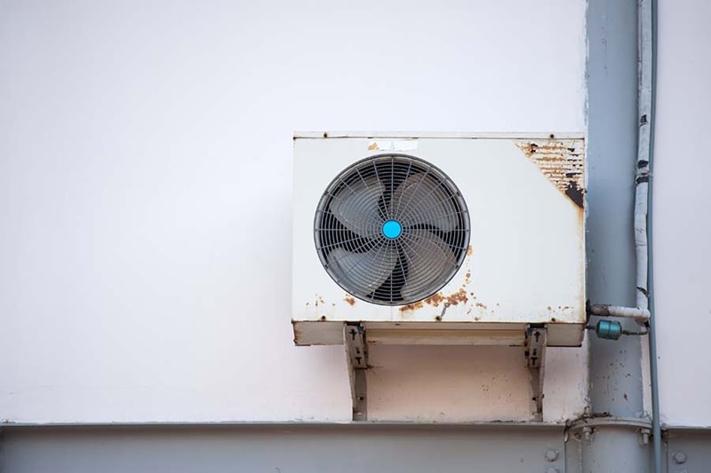 Picture of an old, rusty air conditioner.