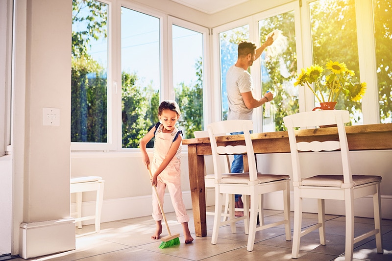 How Environmental Issues Can Affect Your AC. Dad cleaning windows and sweeping floor.