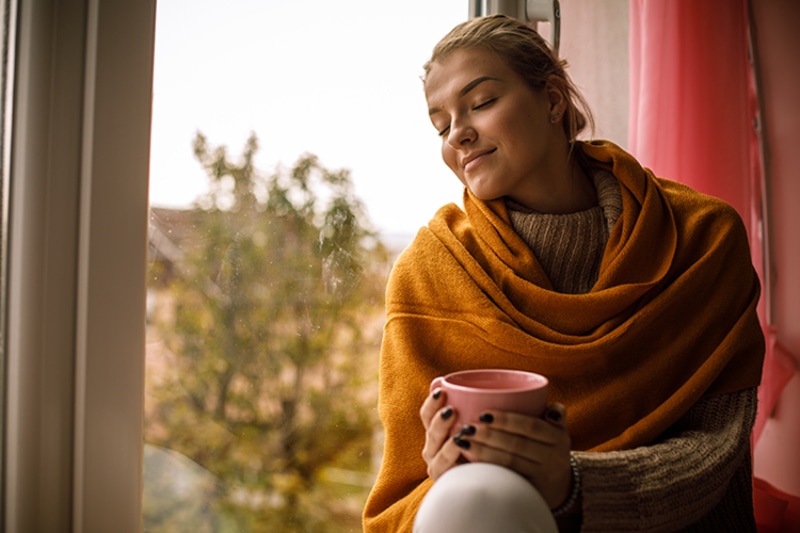 5 Tips to Improve Your Indoor Air Quality This Fall - Lady Wrapped up in a Blanket.